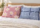 Almohadas florales y a cuadros en cama.webp