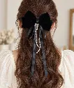 Elegant black bow with pearl strands-2.webp