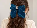 Brunette wearing a teal velvet bow-3.webp
