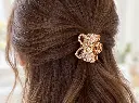 Gold rhinestone bow claw in brown hair-2.webp