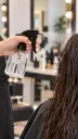 Pulverizador transparente humedeciendo cabello en salón-2 (1).webp